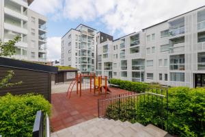 um apartamento com um parque infantil em frente aos edifícios em Close to center and Näsijärvi Lake - free parking, AC, and two double beds em Tampere