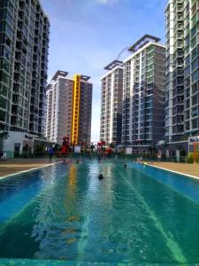une grande piscine en face de grands bâtiments dans l'établissement Harmoni Homes Vista Alam, à Shah Alam