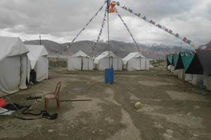 a bunch of tents with a bunch of chairs and a pole at Golden Mark Cottage Tsomoriri Lake in Leh