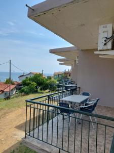 a balcony with tables and chairs on a building at KARAOYLI apartments studios in Kokkino Nero