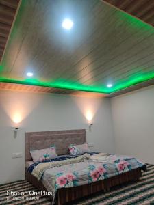 a bedroom with a bed with green lights on it at The Royal Maryul Banquet Hall , Restaurant & Resort - Leh in Stak
