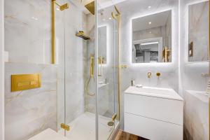 een witte badkamer met een douche en een wastafel bij The One South Kensington in Londen