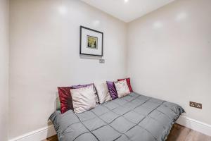 ロンドンにあるThe One South Kensingtonの白い壁の客室の小さなベッド1台分です。