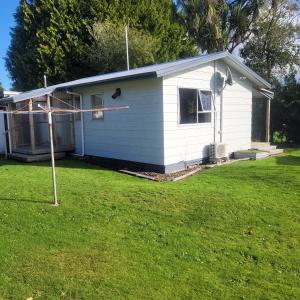 ein kleines weißes Haus mit einem Hof in der Unterkunft Couples Retreat in Reefton