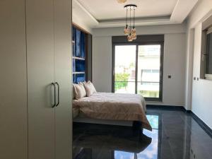 1 dormitorio con cama y ventana grande en Sunny Villa Belek, en Belek