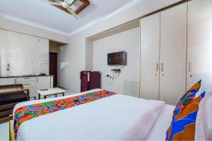 a bedroom with a bed with a colorful blanket at FabHotel Lepsi Inn in Bangalore