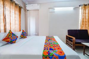 a bedroom with a bed and a chair at FabHotel Lepsi Inn in Bangalore