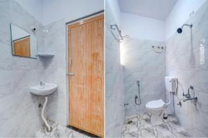two pictures of a bathroom with a toilet and a sink at FabHotel Lepsi Inn in Bangalore