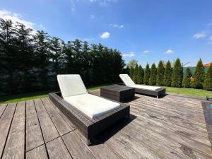 twee stoelen en een tafel op een houten terras bij GOLF POOL VILLA in Šajdíkove Humence