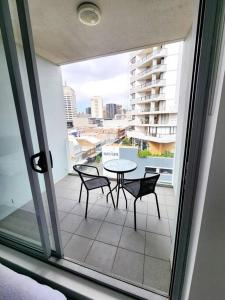 a patio with a table and chairs on a balcony at Bondi Junction Beauty in Sydney
