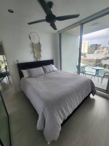 1 dormitorio con 1 cama grande y ventilador de techo en Bondi Junction Beauty en Sídney