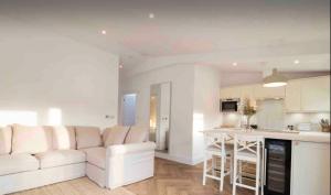 a living room with a white couch and a kitchen at Palm Cottage in Kent +15 photos