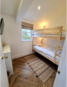 um quarto com 2 beliches e uma janela em Palm Cottage em Kent