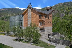 a wooden house with a mountain in the background at Welcomhotel By ITC Hotels, Hamsa Manali in Manāli