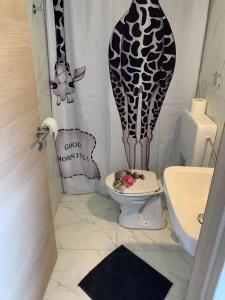 a bathroom with a giraffe shower curtain and a toilet at L&G ROOMS in Ljubljana