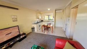 a kitchen and a living room with a tv and a table at Rise n' Shine - min stay 4 nights in Port Pirie