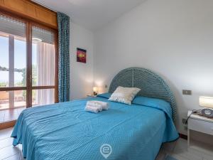 Un dormitorio con una cama azul con toallas. en Rosemary Apartment, en Capitana
