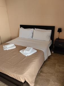 a bed with two white towels on top of it at Katerina Apartments in Kalamata