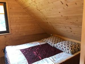 a bed in a log cabin with a wooden wall at U Bartków in Kościelisko