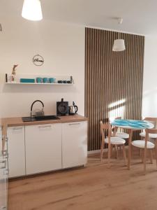 夏諾查特的住宿－Uroczy Apartament Happy 31 - bez limitu Netflix，厨房以及带桌椅的用餐室。