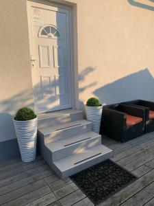 a white door with two potted plants next to a porch at L&G ROOMS in Ljubljana
