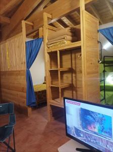 a computer monitor in a room with a bunk bed at Habitación Da Moura in Maus de Salas