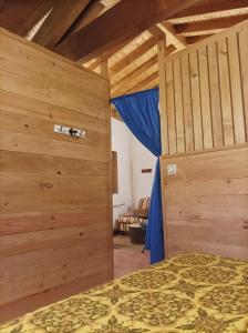 a bedroom with a bed and a wooden wall at Habitación Da Moura in Maus de Salas