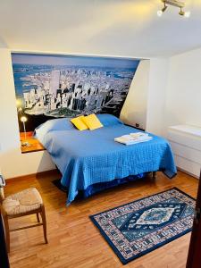 um quarto com uma cama azul com um quadro de uma cidade em Loft in centro vista Mare em Pescara