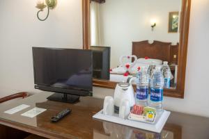 einen Schreibtisch mit einem TV und einem Spiegel auf dem Tisch in der Unterkunft Happy Life Village Dahab in Dahab