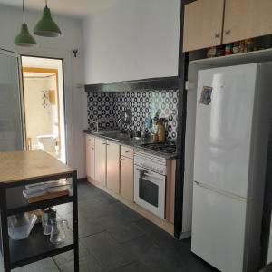 a kitchen with a stove and a white refrigerator at Mediterranien Terrace in Calella