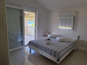 Schlafzimmer mit einem Bett und einer Glasschiebetür in der Unterkunft Apartman Lugović in Šibenik
