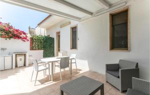 un patio con mesa y sillas en 3 Bedroom Nice Home In St, Maria Del Focallo, en Santa Maria del Focallo