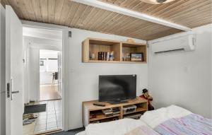een slaapkamer met een bed en een tv aan de muur bij 2 Bedroom Amazing Home In Sams in Permelille