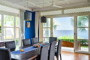 a dining room with a table and chairs with a view of the ocean at Raaga Samudra Villa in Padangbai