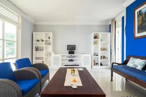 a living room with a coffee table and blue chairs at Raaga Samudra Villa in Padangbai