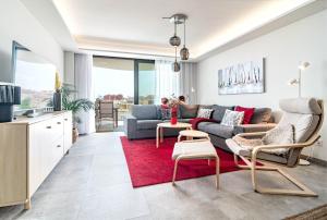 sala de estar con sofá y alfombra roja en INF46P - Infinity Estepona by Roomservices, en Estepona