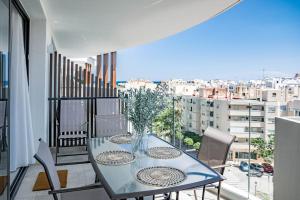 ein Tisch mit Stühlen und einer Vase mit Blumen auf einem Balkon in der Unterkunft INF26H- Comfortable and spacious city apartment in Estepona