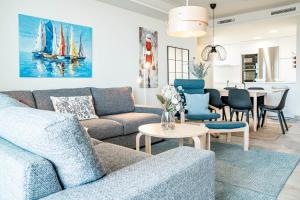 ein Wohnzimmer mit Sofa, Stühlen und einem Tisch in der Unterkunft INF26H- Comfortable and spacious city apartment in Estepona