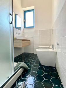 łazienka z wanną, toaletą i umywalką w obiekcie Appartamenti vicini al mare a Giglio campese w mieście Campese