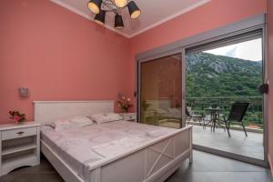 1 dormitorio con 1 cama y balcón en Villa Montenegrina, en Petrovac na Moru