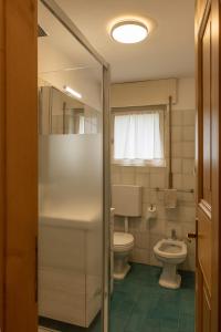 y baño con aseo y lavamanos. en Sorapis Mini - Monolocale Panoramico, en Cortina dʼAmpezzo