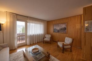 sala de estar con sofá y mesa en Sorapis Mini - Monolocale Panoramico, en Cortina dʼAmpezzo