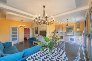 a living room and kitchen with a blue couch and a table at Villa Montenegrina in Petrovac na Moru