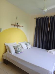 - une chambre avec un grand lit blanc et des rideaux noirs dans l'établissement YellowMellow, à Kilifi