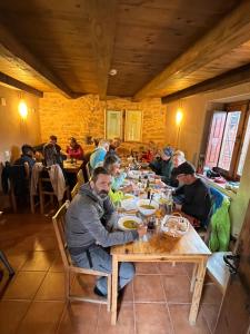 um grupo de pessoas sentadas numa mesa num restaurante em Albergue Rural Las Águedas em Murias de Rechivaldo