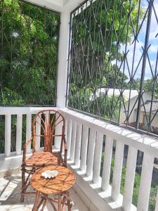 une chaise et une table sur une terrasse couverte dans l'établissement YellowMellow, à Kilifi