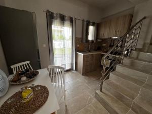 a kitchen with a table and chairs and a staircase at Limoncello Villas in Vourvourou