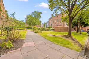a walkway in a park with trees and buildings at Flat in Glasgow City in Glasgow