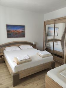 a bedroom with two beds and a mirror at Apartments Katica in Metajna