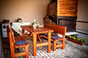 a wooden table with two chairs and a table with a fireplace at Kata Cottage in Szanda